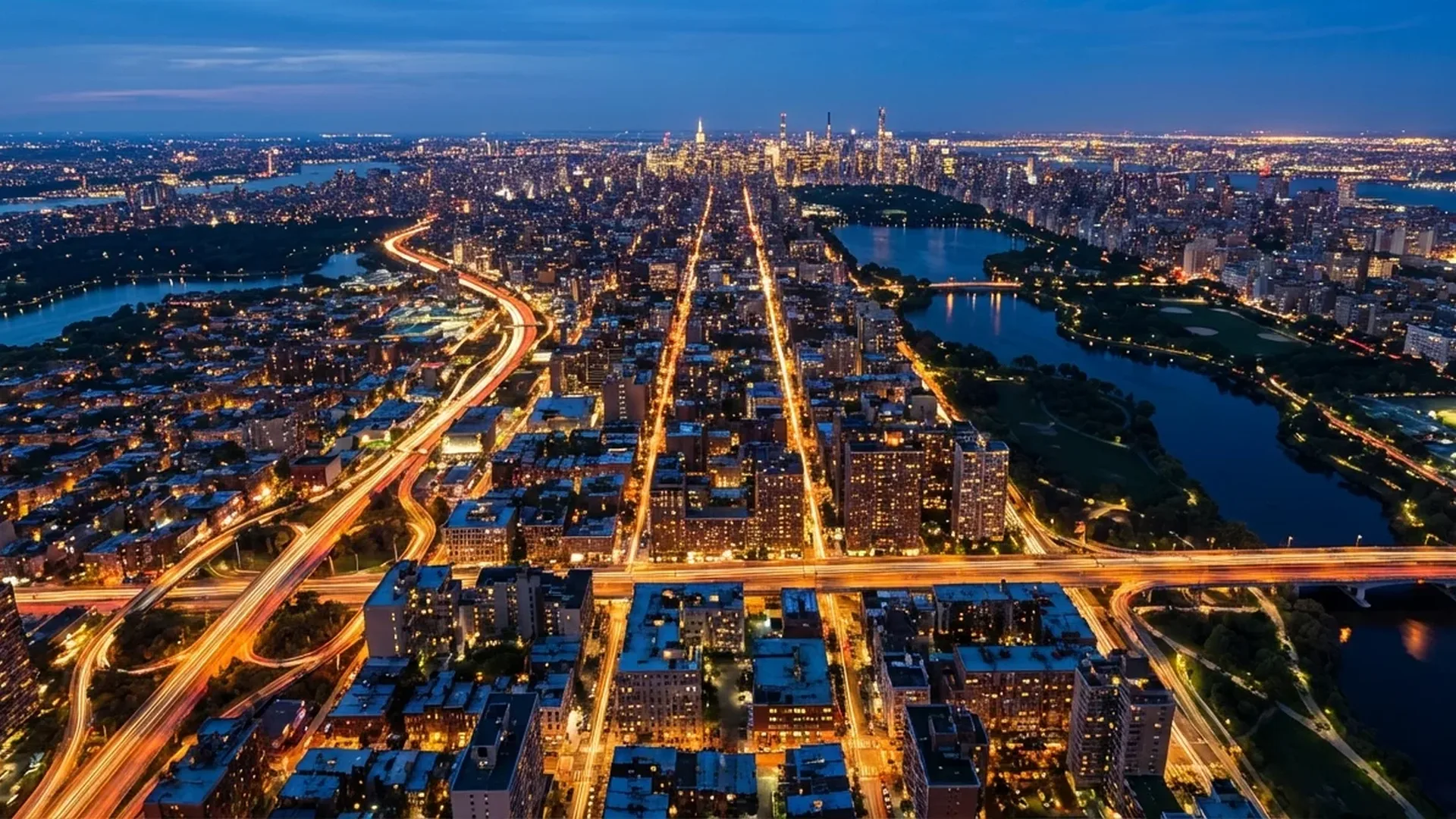 Night drone photography - illuminated cityscape captured from above at blue hour showing light trails and urban glow