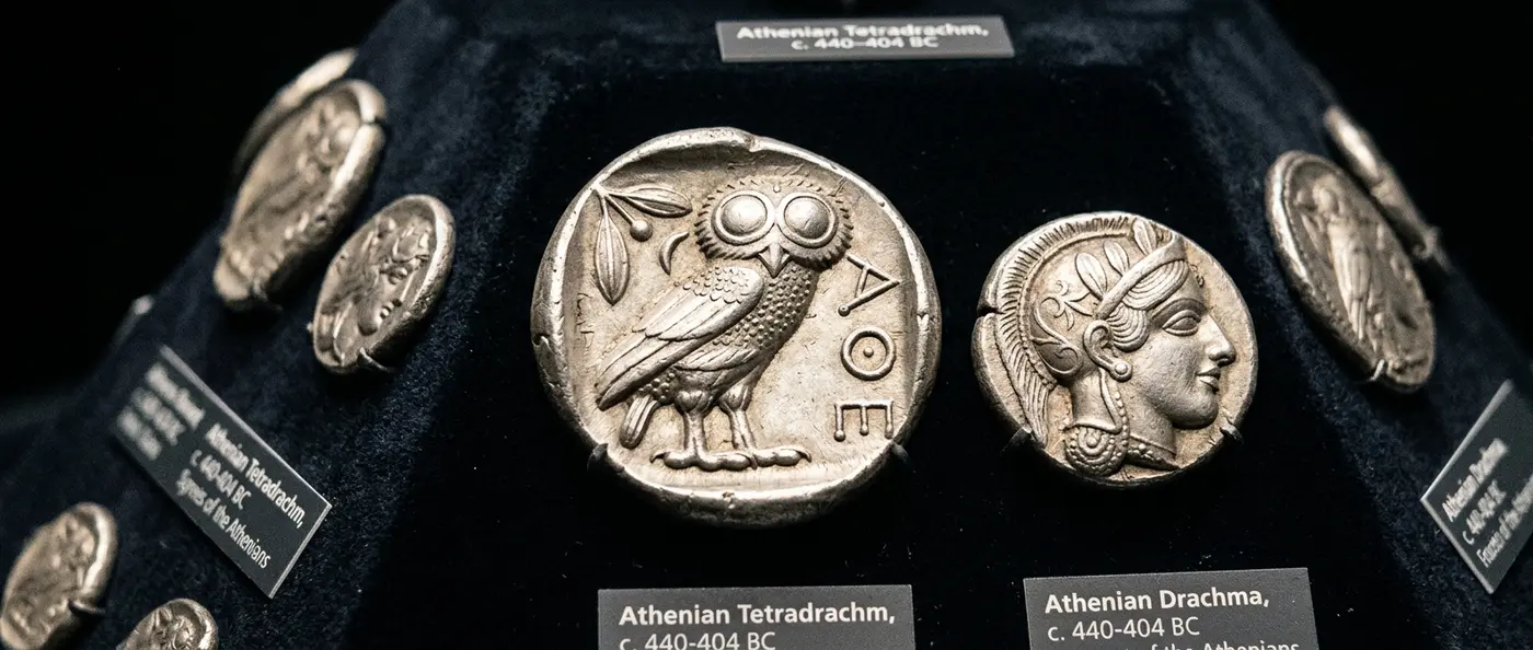 Ancient Greek coin featuring Athena and owl, symbol of the birth of money