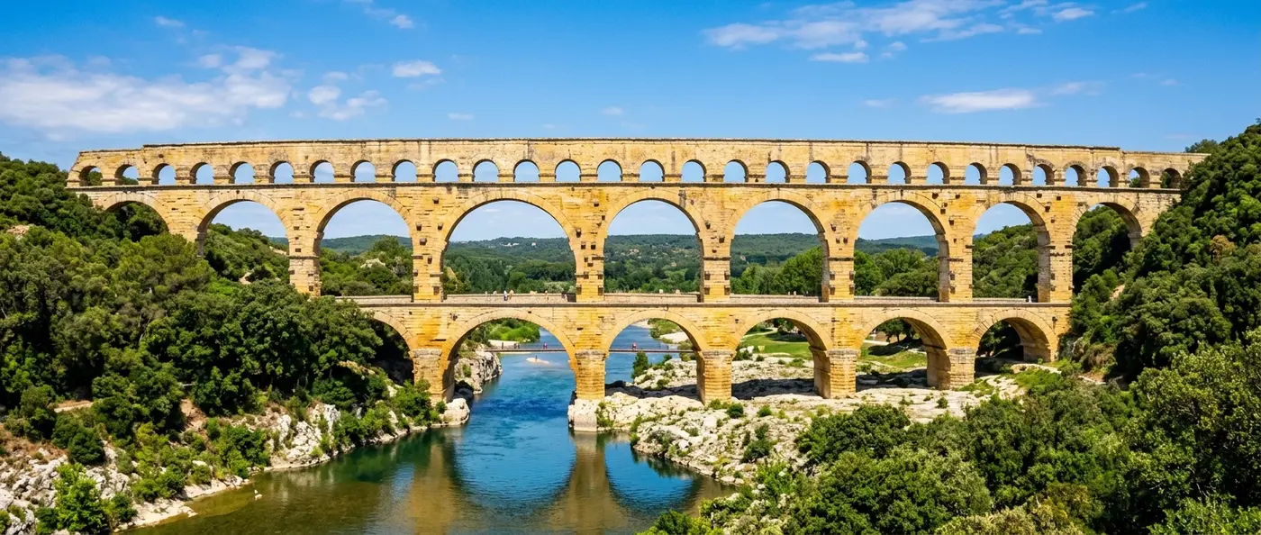 Ancient Roman aqueduct with multiple stone arches crossing a valley